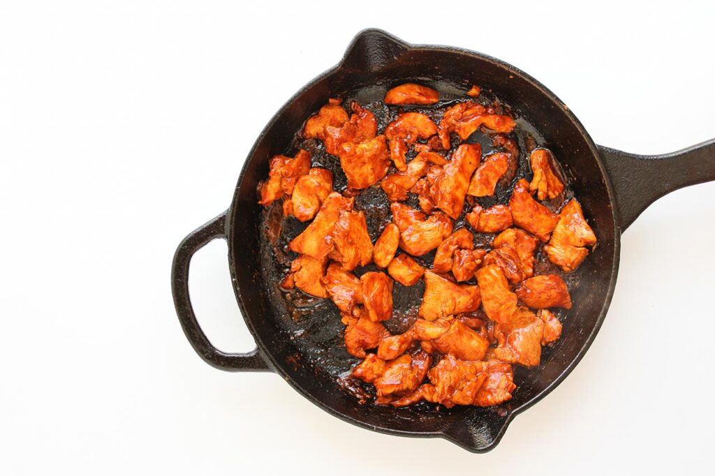 Cooked chicken chunks in a skillet.