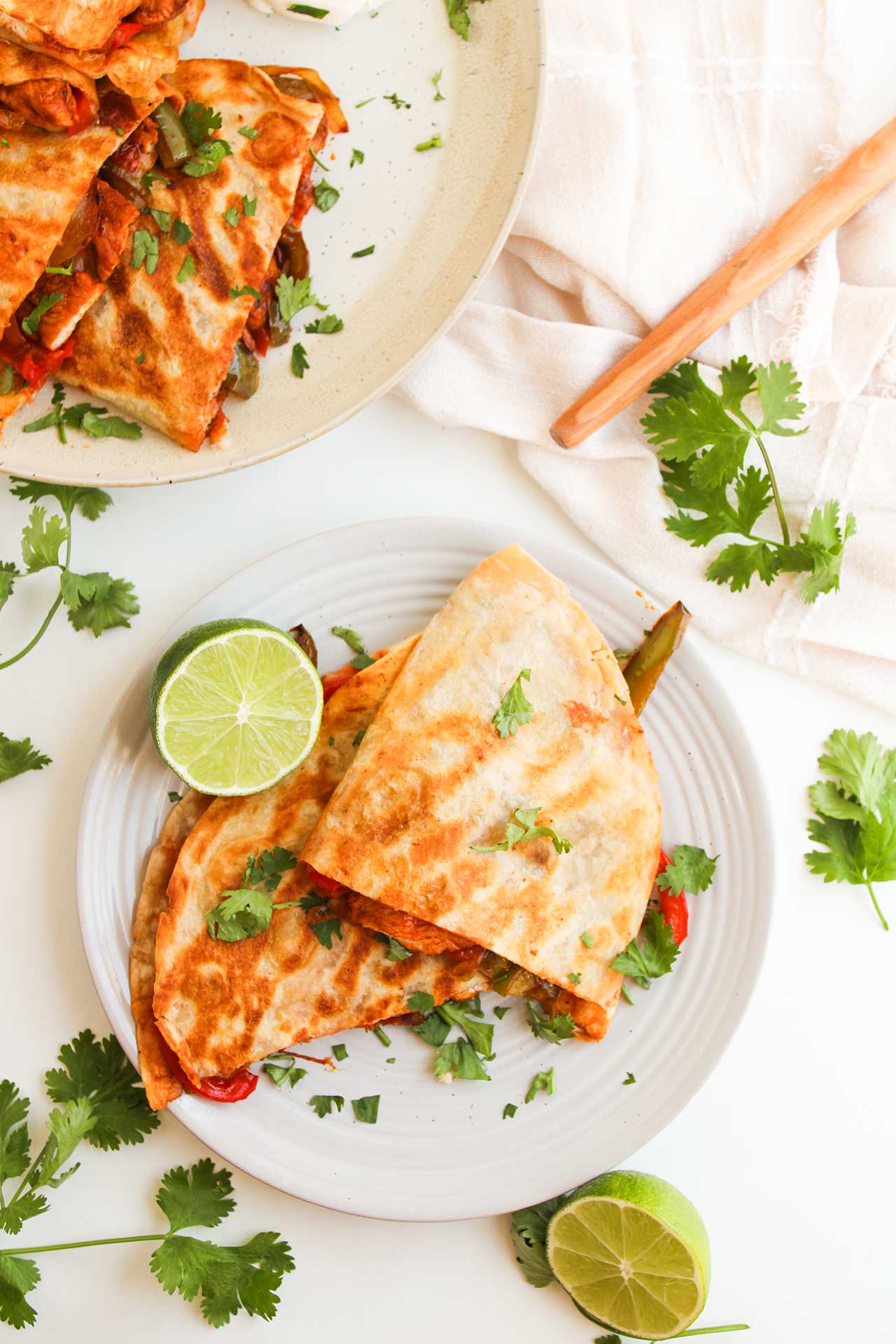 Overhead focus. Two Chicken Fajita Quesadillas on a white plate.