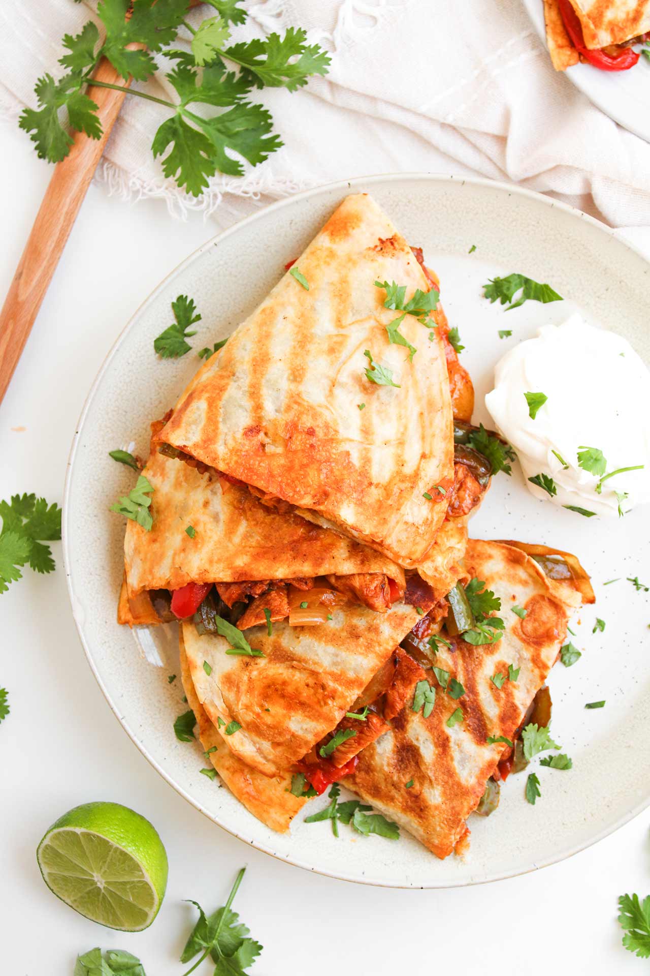 Overhead focus. Stacked Chicken Fajita Quesadillas on a white plate.