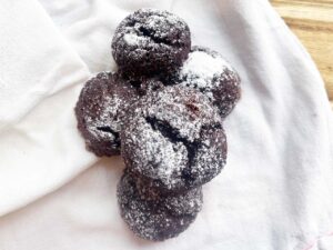 A pile of Oat Flour Chocolate Crinkle Cookies on a white towel.