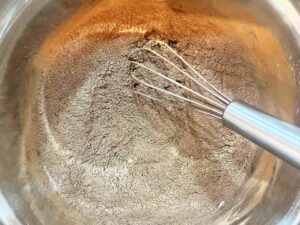 Dry ingredients for Oat Flour Chocolate Crinkle Cookies whisked together in a mixing bowl.