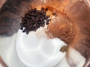 Optional chocolate chips added to dry ingredients for Chocolate Zucchini Bread in a mixing bowl.