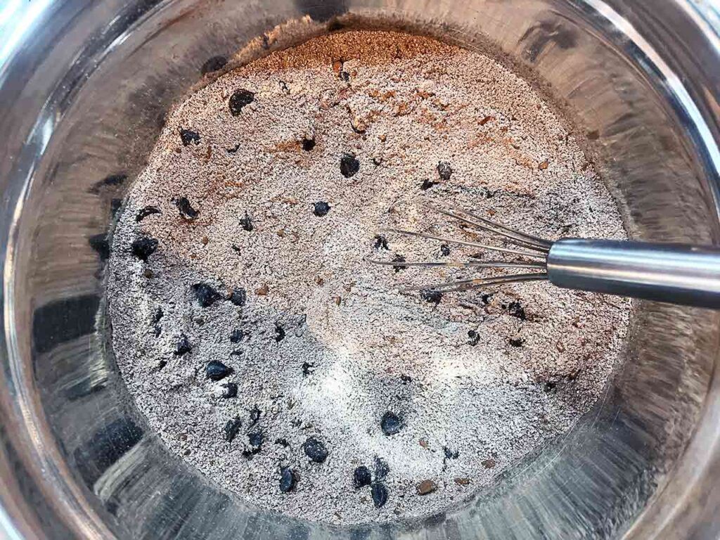 Dry ingredients in a mixing bowl, whisked together. A whisk rests in the bowl.