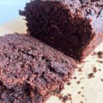 Side front focus. A sliced loaf of Chocolate Zucchini Bread on a cutting board.