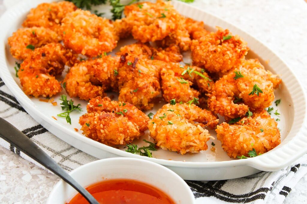 Front focus. A white platter of Crispy Coconut Shrimp.