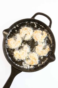 Coated shrimp placed in hot oil.