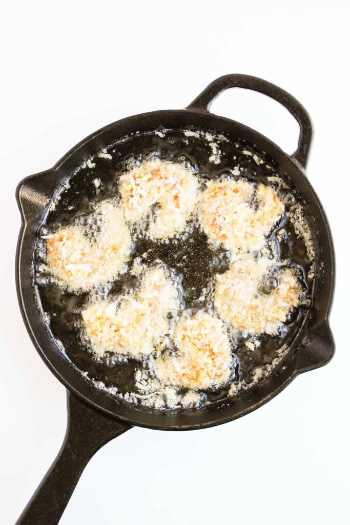 Coated shrimp placed in hot oil.