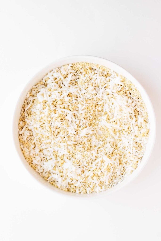 Overhead focus. A white bowl of mixed coconut and bread crumbs.