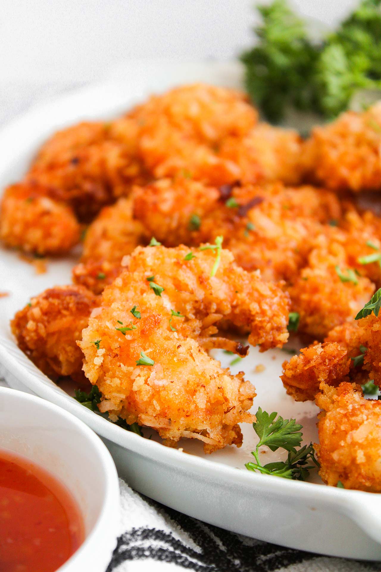 Closeup focus. A white platter of Crispy Coconut Shrimp.