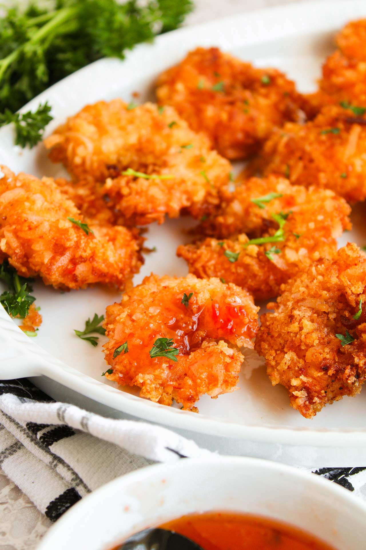 A white platter holds a batch of Crispy Coconut Shrimp.