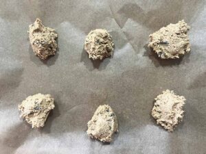 Balls of Oat Flour Chocolate Chip Cookie dough on a parchment-lined cookie sheet.