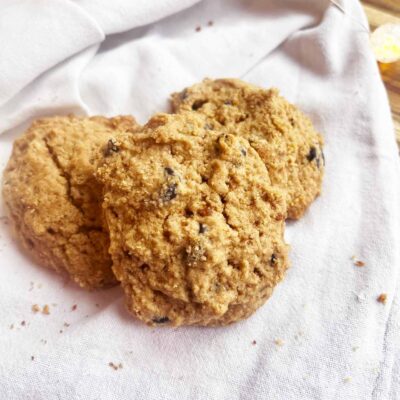 Closeup focus. Three Oat Flour Chocolate Chip Cookies on a white towel.