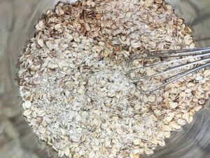 Dry ingredients for Oat Flour Oatmeal Raisin Cookies whisked together in a mixing bowl.
