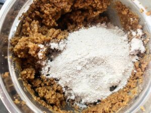 Dry ingredients added to wet ingredients for Oat Flour Peanut Butter Cookies in a mixing bowl.