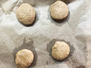 Oat Flour Sugar Cookie dough formed and placed on a parchment-lined baking pan for baking.