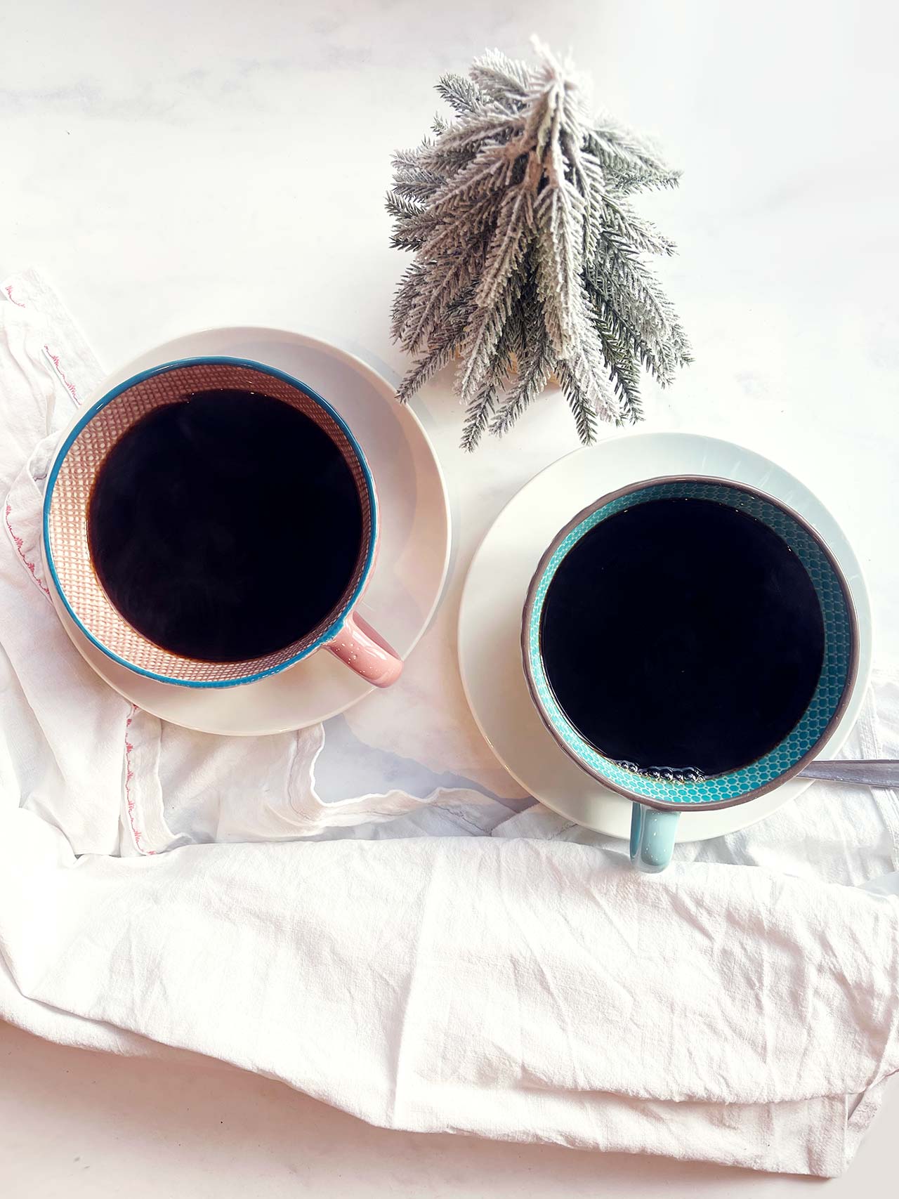 Overhead focus. Two mugs on saucers filled with Spiced Coffee.