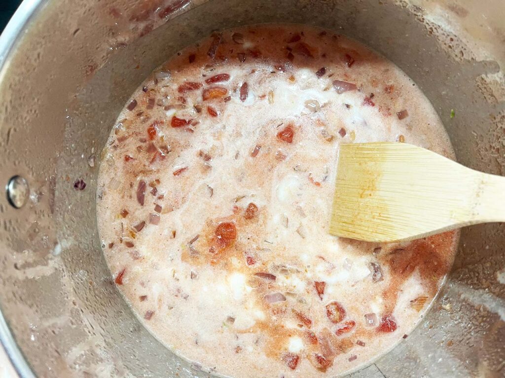 Coconut milk and diced tomatoes added to the pot.