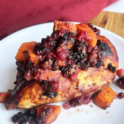 A single Sheet Pan Cranberry Chicken breast on a white plate.