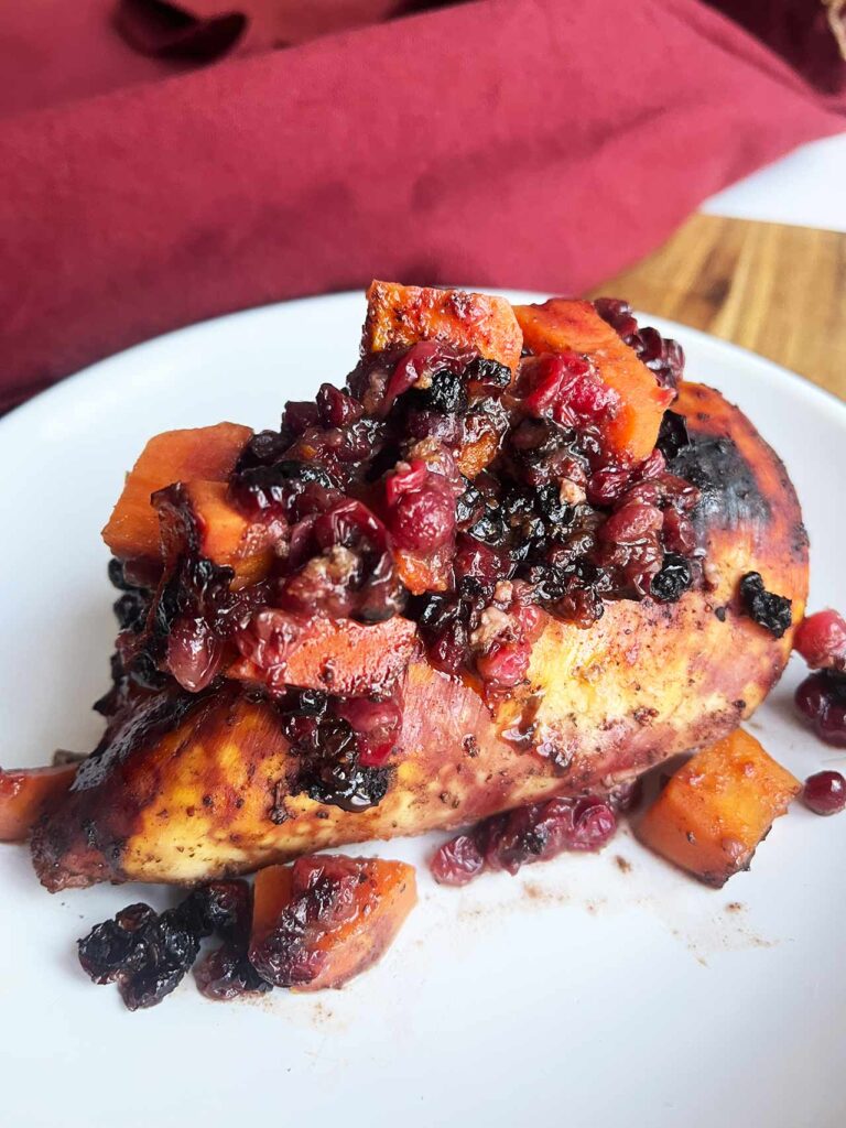A single Sheet Pan Cranberry Chicken breast on a white plate.
