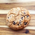 The finished chocolate chip cookie on a wood surface.
