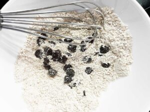 Chocolate chips whisked into dry cookie ingredients.