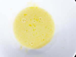 Milk and butter whisked together in a white bowl.