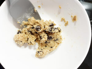 Chocolate chip cookie dough mixed together in a white bowl.