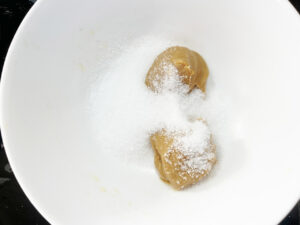 Peanut butter and sweetener in a mixing bowl.