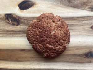 Overhead focus. A single snickerdoodle cookie on a wood surface.