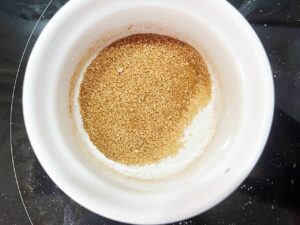 Cinnamon and sweetener mixed together in a mixing bowl.
