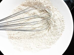 Dry sugar cookie ingredients whisked together in a mixing bowl.