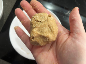 Sugar cookie dough rolled into a ball in a hand.