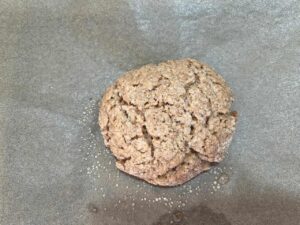 A single baked sugar cookie cooling on the pan.