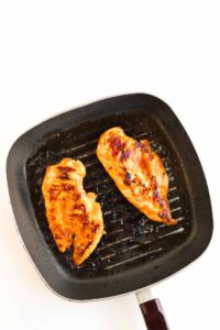 Cooked chicken breasts in a grill skillet.