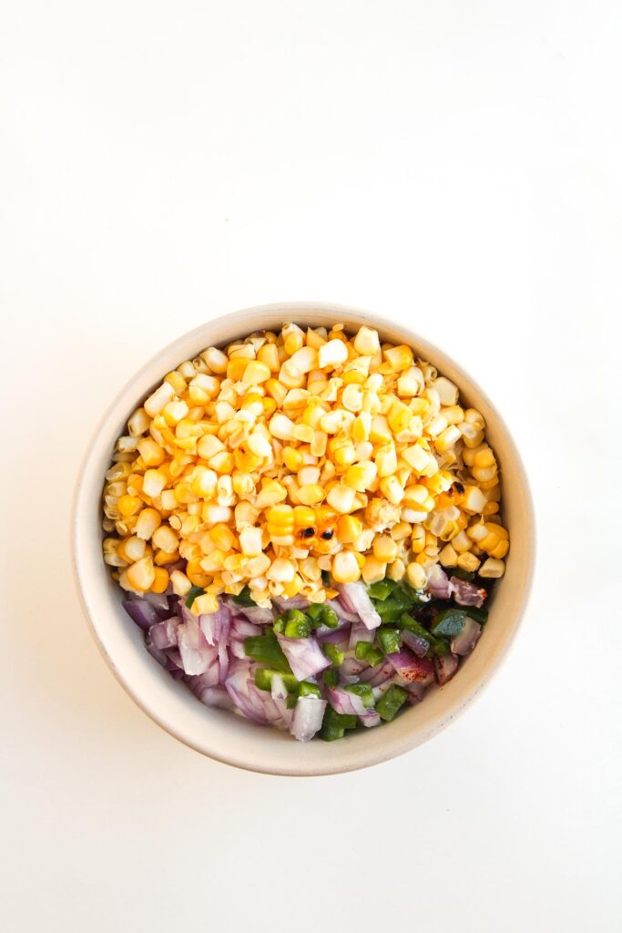 Mixing the street corn topping together in a bowl.