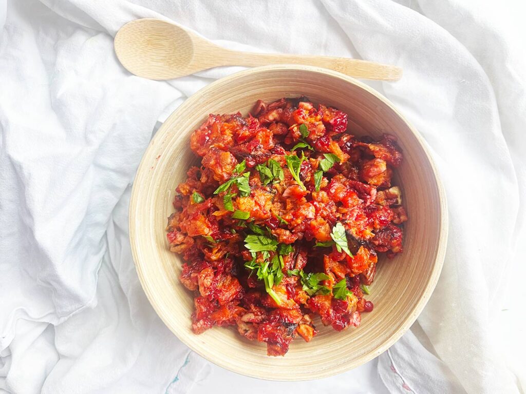 Overhead focus. A wood bowl on a white background. Bowl filled with Sweet Potato Cranberry Salad