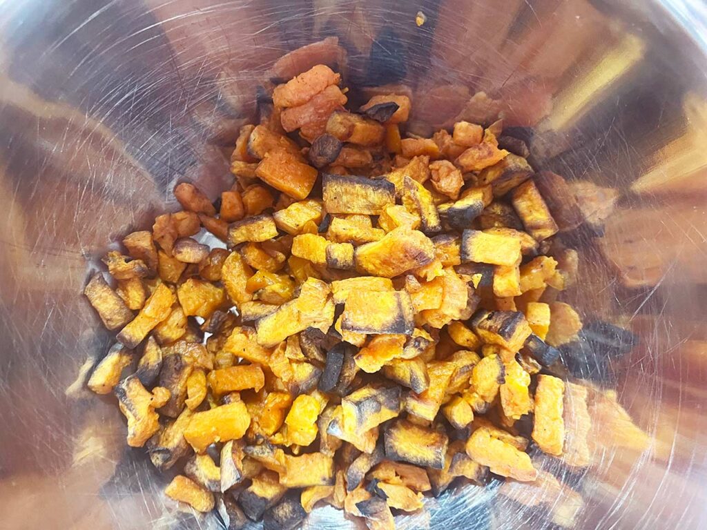 Roasted sweet potato chunks in a mixing bowl.
