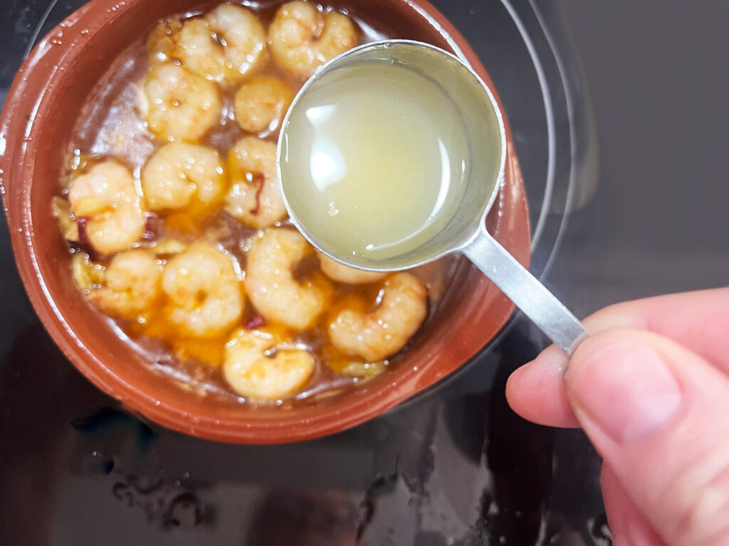 Adding lemon juice to the shrimp.