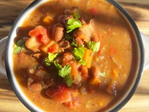 Overhead focus. Closeup of white bowl filled with Mexican Pinto Bean Soup.