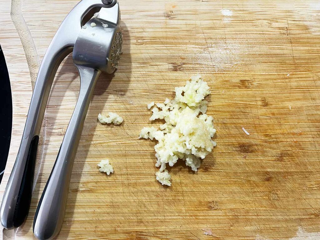 Pressed garlic on a cutting board.