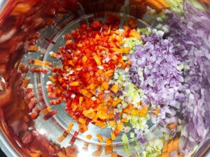 Chopped veggies added to a pot with warm oil.