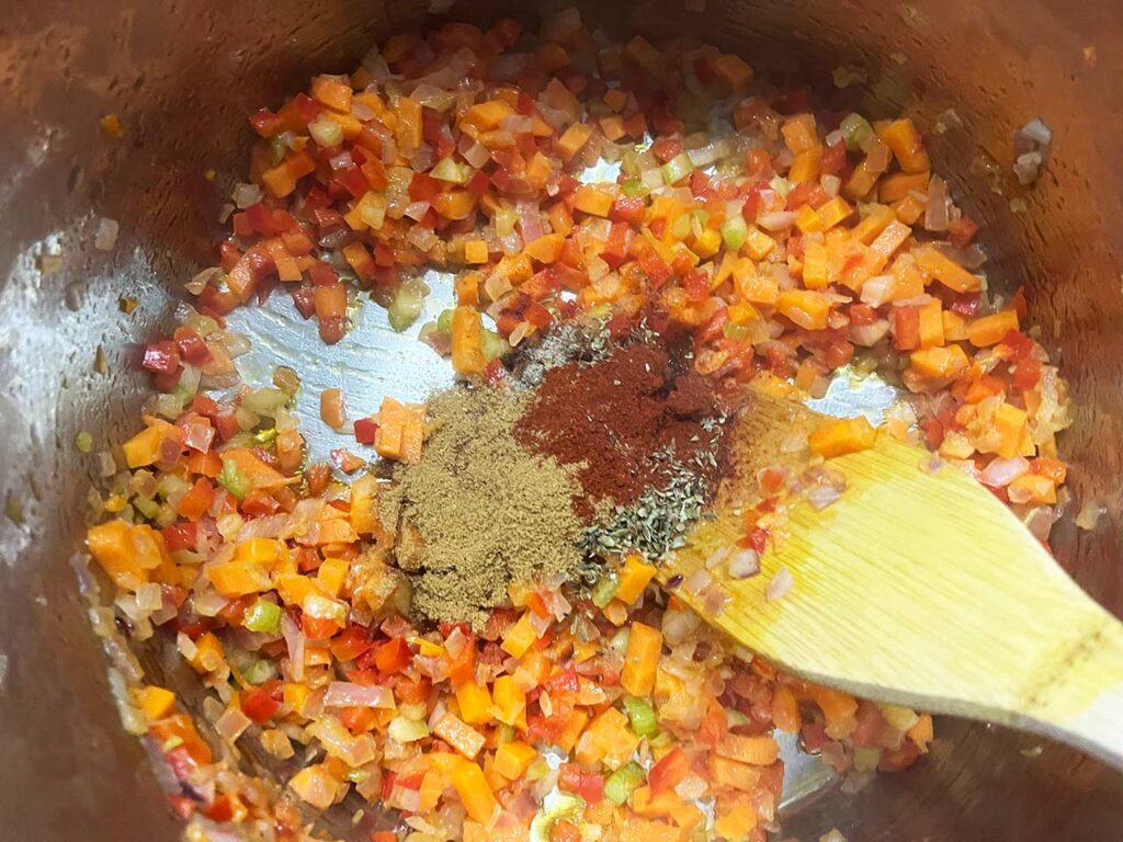 Spices added to cooked veggies in a pot.