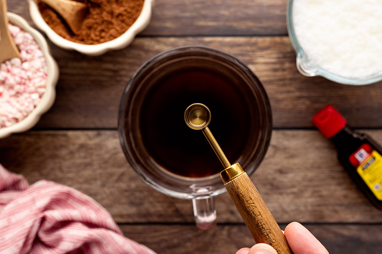 Adding peppermint extract to coffee.