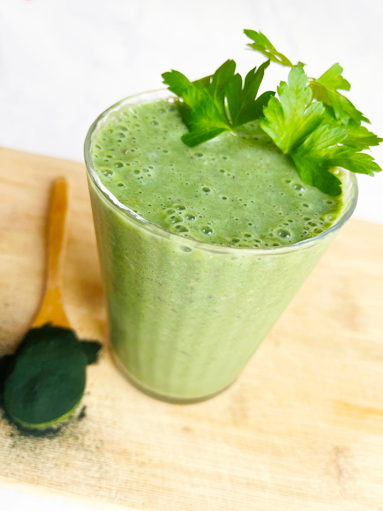 Angled front view of a glass filled with Spirulina Smoothie.