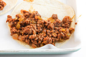 Adding filling to the tortillas.