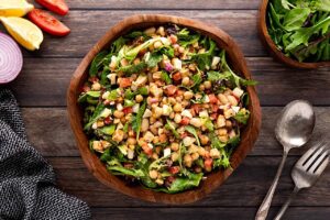 Overhead focus. A wood bowl filled with High Protein Dense Bean Salad.