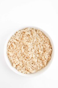 Cooked brown rice added to a bowl.