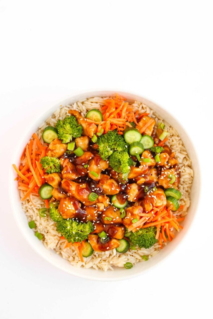 Overhead focus. A Teriyaki chicken bowl in a white bowl on a white background.