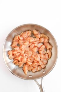 Chicken chunks in a skillet.
