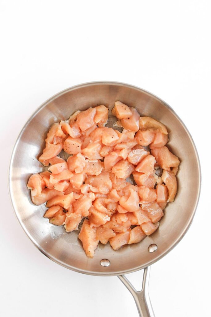 Chicken chunks in a skillet.